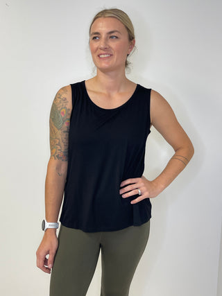  black sleeveless top and green leggings against a white background