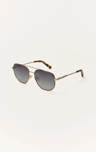Sunglasses with gold frame and tortoiseshell accents on a white background