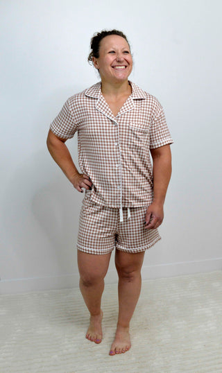 Woman wearing a checkered pajama set against a white background