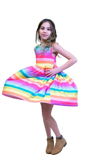 Young girl wearing a colorful striped dress against a white background