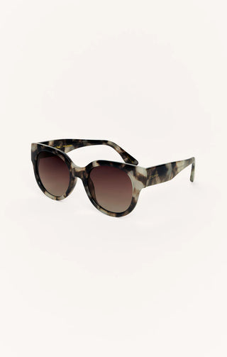Sunglasses with tortoiseshell frame and brown gradient lenses on a white background