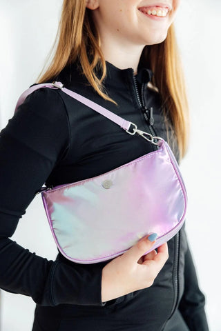 Girls wearing a iridescent crossbody bag with a plain background