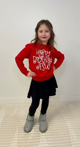 Child wearing a red sweatshirt with 'Happy Birthday Jesus' text on a white background