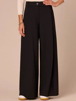 Black wide-leg pants worn by a person on a beige background