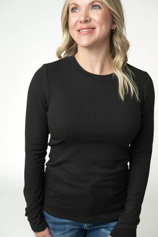 Woman wearing a black long-sleeve top against a white background