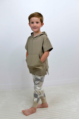 boy wearing a driftwood short sleeve hood with kangaroo pocket and camo joggers