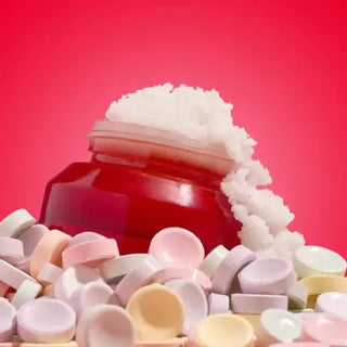 Red jar with white cream on a red background with colorful smarties candie around