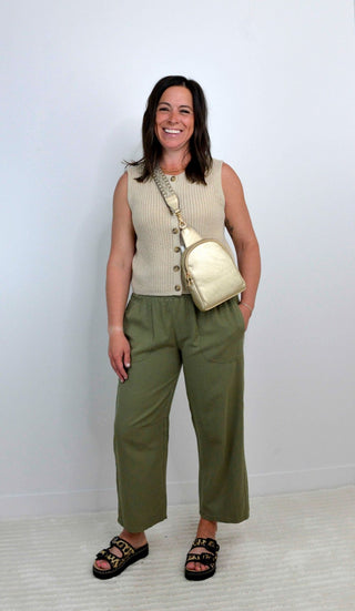 woman wearing a smocked olive green wide leg pant with khaki sleeveless sweater tank top