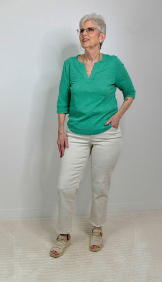 woman wearing jade split neck top with stone colored pants