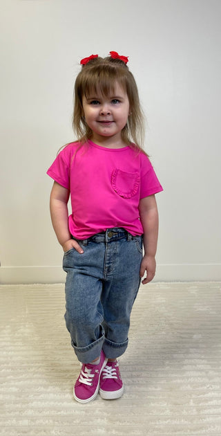 Child wearing a pink shirt and blue jeans with a white background