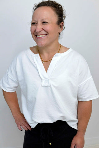 woman wearing a white split neck boxy tee