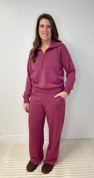 Woman wearing a vintage rose tracksuit against a white background