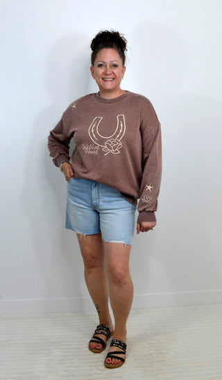 brown sweatshirt with a horseshoe embroidered detail and the words wild at heart