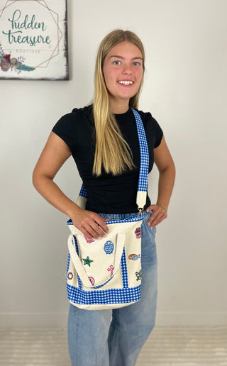 Woman wearing a blue checkered crossbody bible bag with a white pocket and embroidered designs.